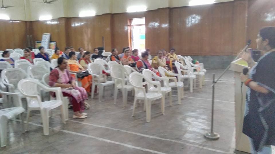 Dr. Renu Goyal speaking to women at a seminar in a hall